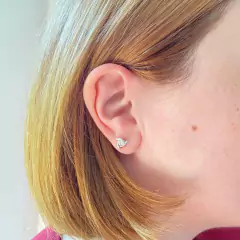 detalhe na modelo do brinco joia prata 925 em formato de triângulo com ponto luz zircônia