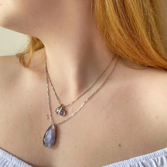 detalhe na modelo do colar semijoia em gota cristal calcedônia cor ametista banhado a ródio