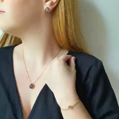 detalhe na modelo do conjunto semijoia gota cristal cor ametista banhado a ouro 18k