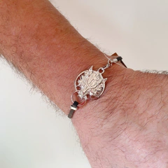 detalhe no pulso da pulseira semijoia handmade de couro sintetico preto com pingente lobo banhado a ródio branco