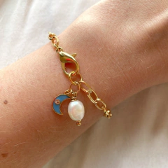 detalhe da pulseira semijoia energética banhada a ouro com pingente de Lua esmaltada em cor azul celeste e pérola para trabalhar a intuição feminina