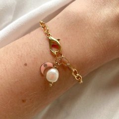 detalhe da pulseira semijoia energética banhada a ouro com pingente de Lua esmaltada em cor salmão e pérola para trabalhar a intuição feminina
