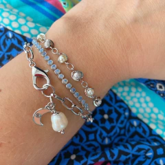 detalhe no pulso da combinação com a pulseira semijoia energética banhada a ródio com pingente de Lua e pérola para trabalhar a intuição feminina