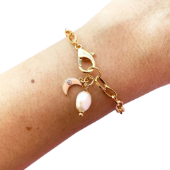 detalhe da pulseira semijoia energética banhada a ouro com pingente de Lua esmaltada em cor salmão e pérola para trabalhar a intuição feminina