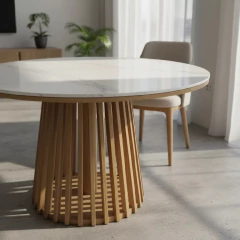 Mesa redonda con tapa simil mármol blanco Neolith y base de listones de madera clara en comedor moderno