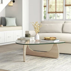 Mesa Noguchi base Natural con tapa de vidrio y patas de madera clara en forma triangular.