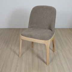 Silla moderna con asiento y respaldo tapizados en tela marron y patas de madera clara