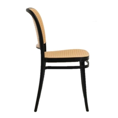 Silla Thonet de PVC negra para uso exterior, con respaldo curvado y asiento de mimbre.