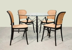 Silla Thonet de PVC negra para exteriores, con diseño elegante y asiento de mimbre, en un entorno moderno.