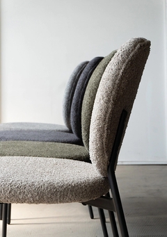 Silla Dina Chenille de color negro con base metálica, tapizada en un tejido suave y texturizado.