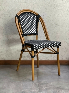 Silla de rattan y aluminio beige para jardín, con diseño trenzado negro y blanco.