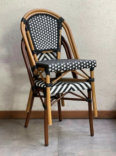 Silla de rattan y aluminio beige para jardín, con diseño trenzado negro y blanco.