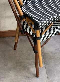 Silla de rattan y aluminio beige para jardín, con diseño trenzado negro y blanco.