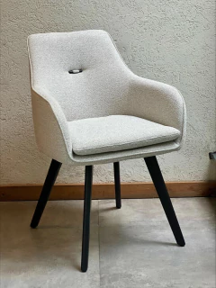 Tres sillones tapizados Fix en tonos gris claro, marrón y gris oscuro, con patas de madera negra, ubicados en un ambiente luminoso de madera.