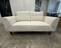 Sofá cama Selene de dos cuerpos en tela bouclé color blanco con cojines y patas de madera en ambiente interior