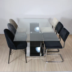 Mesa de comedor Timor con tapa de vidrio transparente y base negra, rodeada por sillas tapizadas en varios colores