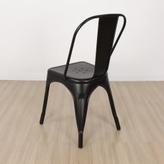 Imagen de una silla Tolix negra mate con respaldo y estructura metálica sobre piso de madera clara