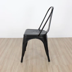 Silla Tolix negra mate de metal vista lateral sobre piso de madera clara
