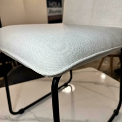 Silla Cori tapizada en chenille color blanco offwhite con estructura de metal negro.