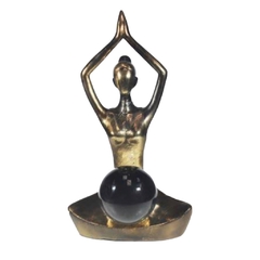 estatua em posição de yoga meditando com bola de cristal