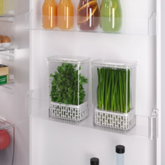 Organizador transparente para temperos frescos com capacidade de 2,3 litros dentro da porta da geladeira, contendo ervas frescas.