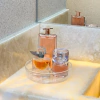 Organizador giratório cristal 18cm na bancada da pia do lavabo com perfumes.