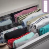 Organizador de roupas em uma gaveta, mostrando uma colmeia invisível com 10 nichos, mantendo as peças dobradas e organizadas.
