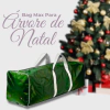 Bolsa organizadora verde para árvore de Natal, com alças brancas, em frente a uma árvore decorada.