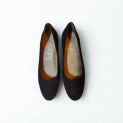 Par de zapatos flat negros de mujer sobre fondo blanco vistos desde arriba