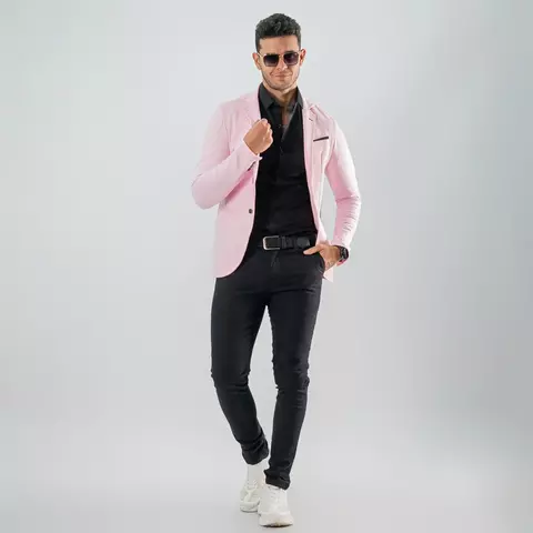 Hombre vistiendo blazer sport rosado slim fit con camisa negra, pantalones oscuros y zapatillas blancas
