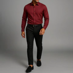 Hombre joven usando camisa vino tinto texturizada de corte slim fit, combinada con pantalón negro de vestir, cinturón negro y mocasines marrones, posando sobre fondo gris claro