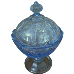 Adicione charme à sua mesa com esta compoteira antiga em vidro azul. Peça única dos anos 50, perfeita para servir ou decorar. Garanta já a sua!