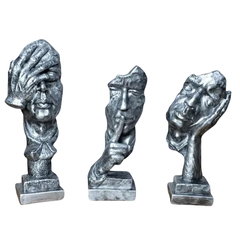 Esculturas decorativas prateadas representando trio de pensadores com gestos de não ver, não ouvir e não falar