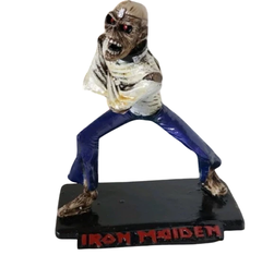 Boneco colecionável do personagem Eddie da banda Iron Maiden em pose de ataque com base preta e nome da banda em vermelho