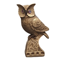 Escultura decorativa de coruja dourada em gesso sobre base com relevo de árvores