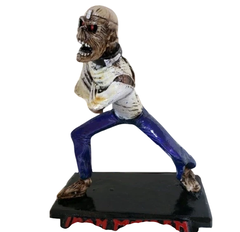 Boneco colecionável do Eddie, mascote da banda Iron Maiden, em pose agressiva com roupas rasgadas e base preta