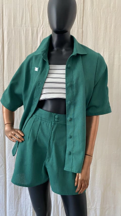Conjunto de camisa celeste verde bandeira com shortinho de alfaiataria, apresentando pences e bolsos laterais, exibido por um manequim em fundo claro.
