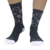 Meias pretas com estampas brancas, usadas por uma pessoa, destacando um design moderno e esportivo.