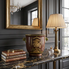 Cachepot oriental em cerâmica terracota com alças ambientado com planta verde ornamental sobre aparador de madeira nobre em sala de estar neoclássica e elegante