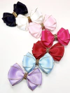 Conjunto de laços coloridos Laço Clara Glamour, incluindo preto, branco, rosa, vermelho, azul e roxo, com detalhes em dourado.
