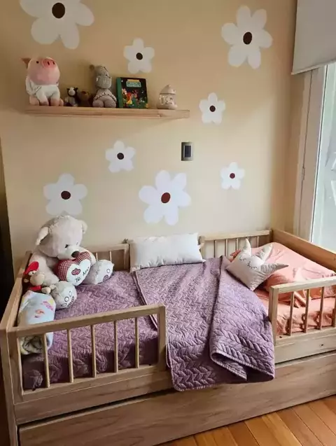Cama carro LP decorada con almohadas y juguetes en un ambiente infantil.