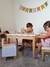 Niños jugando con bloques de madera en una mesa en un ambiente acogedor.