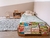 Minicama Astor en una habitación infantil, con libros en la baranda, juego de cama verde y alfombra gris.