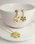 Brinco flor pêndulo efeito martelado folheado em ouro 18k