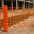 Malla de señalización vial naranja instalada en obra en construcción para delimitar zona de trabajo