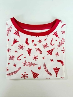 Camiseta natalina branca com estampas vermelhas de elementos natalinos, como árvores,e bengalas de doce.