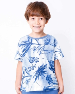 Camiseta floral azul com folhas, combinada com shorts azuis e tênis brancos.