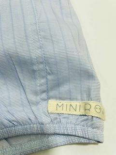 Detalhe de uma jardineira azul claro com etiqueta da marca Mini Row.