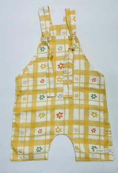 Jardineira floral em amarelo com estampas de flores coloridas e padrão quadriculado.