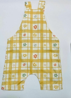 Jardineira floral em amarelo com estampas de flores coloridas e padrão quadriculado.